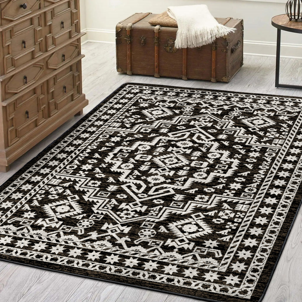 Black and white patterned rug on a wooden floor with a trunk and dresser in the background.